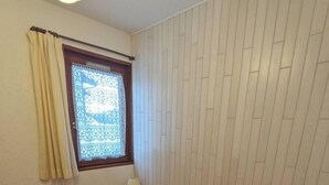 A bedroom with a bed, a window with curtains, a bedside lamp, and a radiator. - 10m from ski slopes, floor -1, balcony, tv, 31m², Aussois (Aussois)
