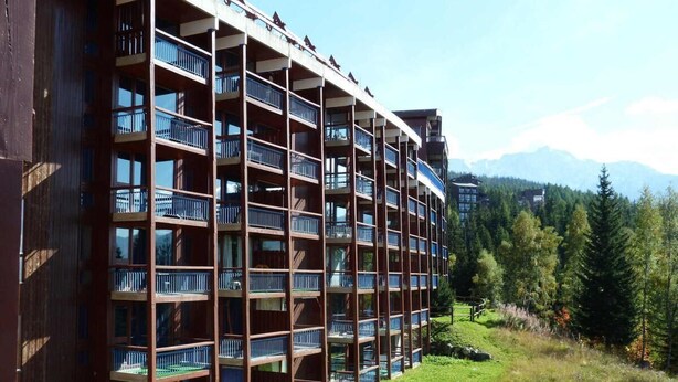 A multi-story hotel with balconies, surrounded by a grassy area and trees. - 50m from resort center, 1st floor, view mountain, balcony, tv, 33m², Les Arcs (Les Arcs)