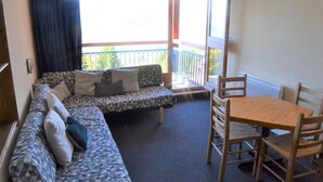 A room with a sofa, a table, and chairs. - 50m from resort center, 1st floor, view mountain, balcony, tv, 33m², Les Arcs (Les Arcs)