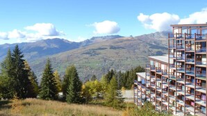 A modern building with multiple balconies overlooking a mountainous landscape. - 50m from resort center, 1st floor, view mountain, balcony, tv, 33m², Les Arcs (Les Arcs)