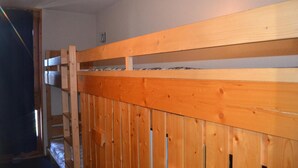 A bunk bed with a wooden headboard and a metal ladder. - 50m from resort center, 1st floor, view mountain, balcony, tv, 33m², Les Arcs (Les Arcs)
