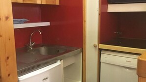 A compact kitchenette with a refrigerator, sink, microwave, and dishwasher. - 10m from ski slopes, 4th floor, view ski slopes, balcony, ski locker, 24m², Les Arcs (Les Arcs)