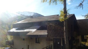 A rustic wooden building with a staircase leading to a door marked "Entrance." - 300m from ski slopes, 5th floor, view forest, balcony, tv, 38m², Les Orres (Les Orres)