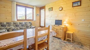 A cozy cabin with a wooden interior, a sofa set, a dining table, a TV, and a lamp. - 3rd floor, balcony, tv, 30m², Aussois (Aussois)