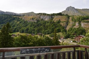 Eine Berglandschaft mit einem Dorf, Holzhäusern und einem Schild mit einer Karte.