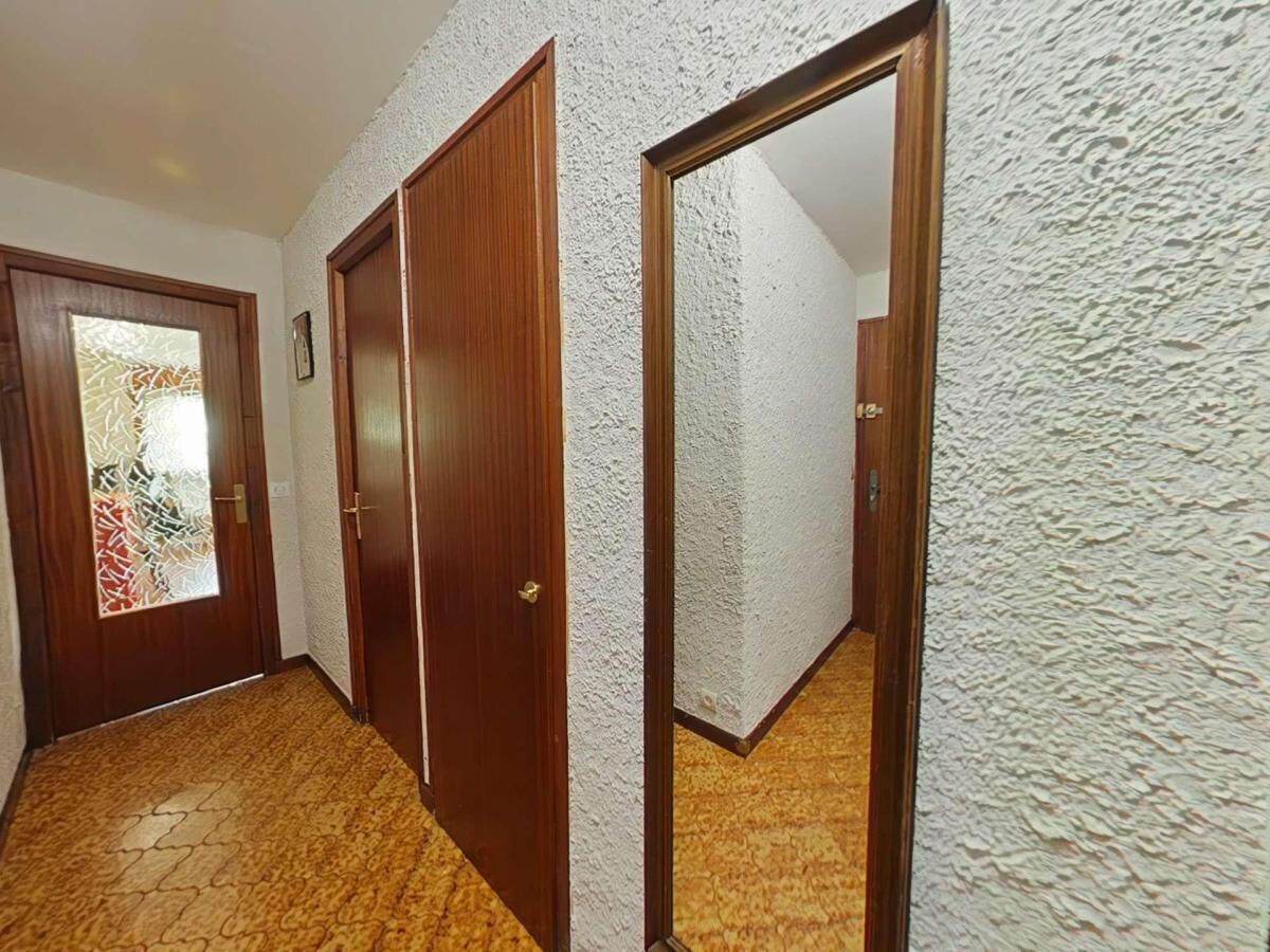 A hallway with wooden doors and textured walls.