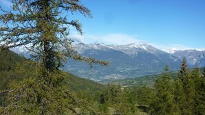 A mountainous landscape with a view of snow-capped peaks and a valley below.