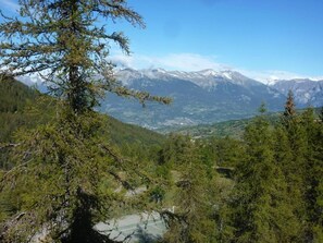 Un paisaje montañoso con vistas a picos nevados y un valle abajo.