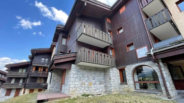A multi-story building with balconies, stone facade, and a clear sky. - 26m from ski slopes, 2nd floor, balcony, tv, ski locker, 35m², Valmorel (Valmorel)