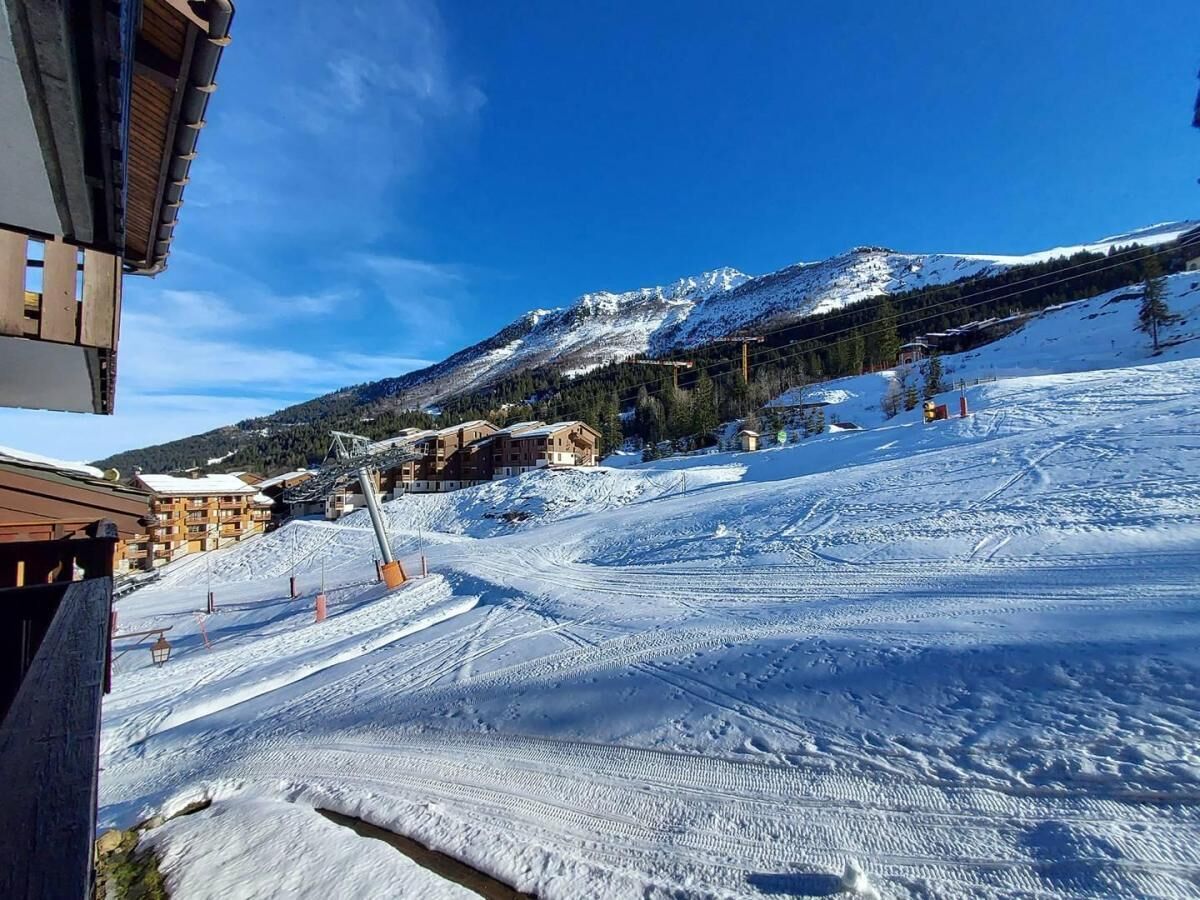 Une piste de ski enneigée, avec des bâtiments en arrière-plan.