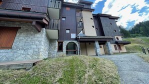 A multi-story building with a stone facade, wooden balconies, and a stone entrance. - 26m from ski slopes, 2nd floor, balcony, tv, ski locker, 35m², Valmorel (Valmorel)