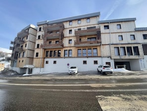 Ein mehrstöckiges Gebäude mit modernem Design, inklusive Balkonen und großen Fenstern.