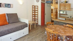 Ein gemütlicher Wohnraum mit Sofa, Esstisch und Küchenzeile.