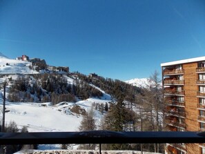 A snow-covered mountain landscape with a building featuring balconies and a wooden facade. - 50m from ski slopes, 4th floor, view mountain, balcony, tv, ski locker, 35m², La Plagne (La Plagne)