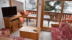 Una habitación acogedora con un mueble bajo de madera para el televisor, un sofá y una mesa.