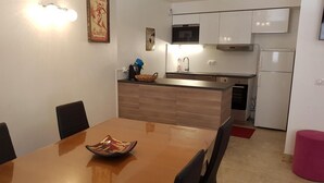 Eine kleine Küche mit einer Holzarbeitsplatte, einer Mikrowelle, einem Herd und einem Kühlschrank.