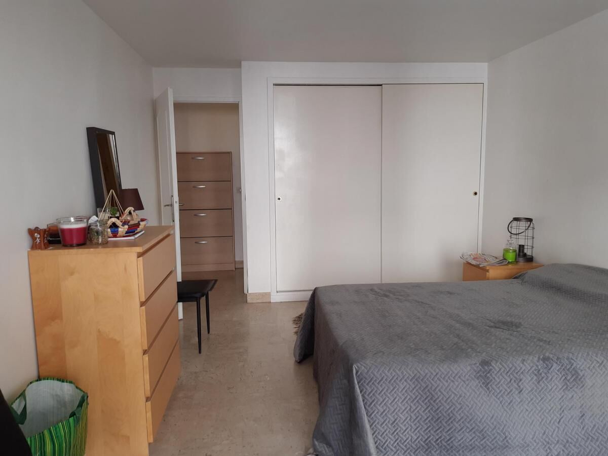 Un dormitorio con cama, cómoda, escritorio y armario.