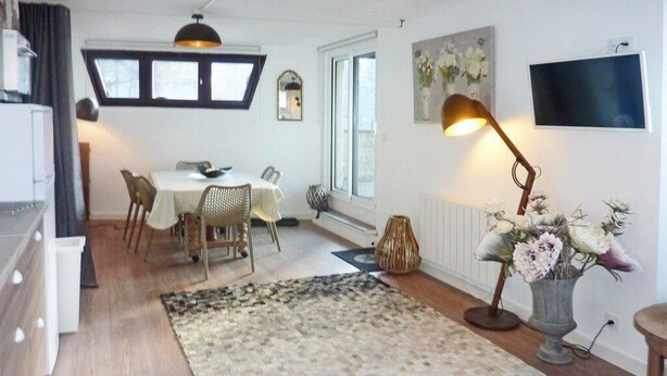 A modern living room with a dining area, a large window, a flat-screen TV, and a decorative lamp. - Ski-in/ski-out & foot of the slopes, 3rd floor, view valley, terrace, tv, ski locker, 55m² (Les Orres)