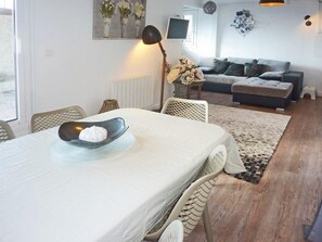 A dining area with a table set for two, a sofa in the background, and a floor lamp. - Ski-in/ski-out & foot of the slopes, 3rd floor, view valley, terrace, tv, ski locker, 55m² (Les Orres)