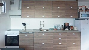 A compact kitchen with wooden cabinets, a built-in oven, a microwave, and a sink. - Ski-in/ski-out & foot of the slopes, 3rd floor, view valley, terrace, tv, ski locker, 55m² (Les Orres)