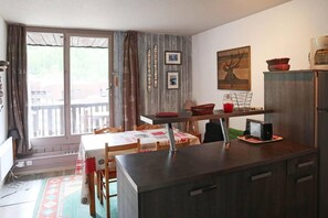Une cuisine de taille réduite avec un coin repas, une grande fenêtre et un tableau accroché au mur.