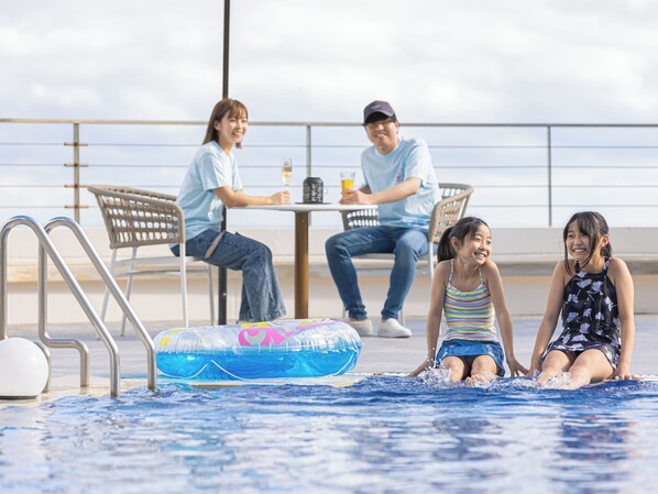 A poolside area with a table and chairs, a pool, and a railing. - Atagawa Ocean Resort (Higashiizu)