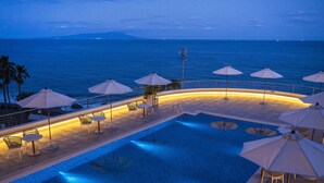 A pool area with lounge chairs and umbrellas, overlooking the sea. - Atagawa Ocean Resort (Higashiizu)