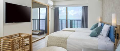 Una habitación de hotel con cama, televisión, balcón y zona de comedor.