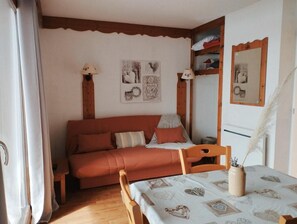 A cozy room with a sofa, a table with a vase, and wall decorations.