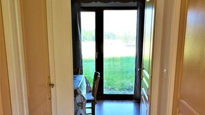 A hallway leading to a dining area with a view of a grassy field. - Ground floor, view mountain, swimming pool, terrace, parking, tv, ski locker, 25m², La Joue du Loup (Agnières-en-Dévoluy)
