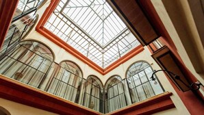 Ein Atrium mit hohen Decken, Bogenfenstern und einem Oberlicht.