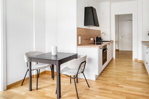 Una cocina moderna con una isla de madera, muebles de cocina blancos y una campana extractora negra.