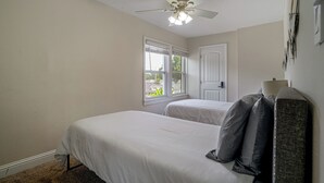 A bedroom with two beds, a ceiling fan, and a window with blinds. - Near Churchill Downs: Pet Friendly, Fenced Yard! (Louisville)