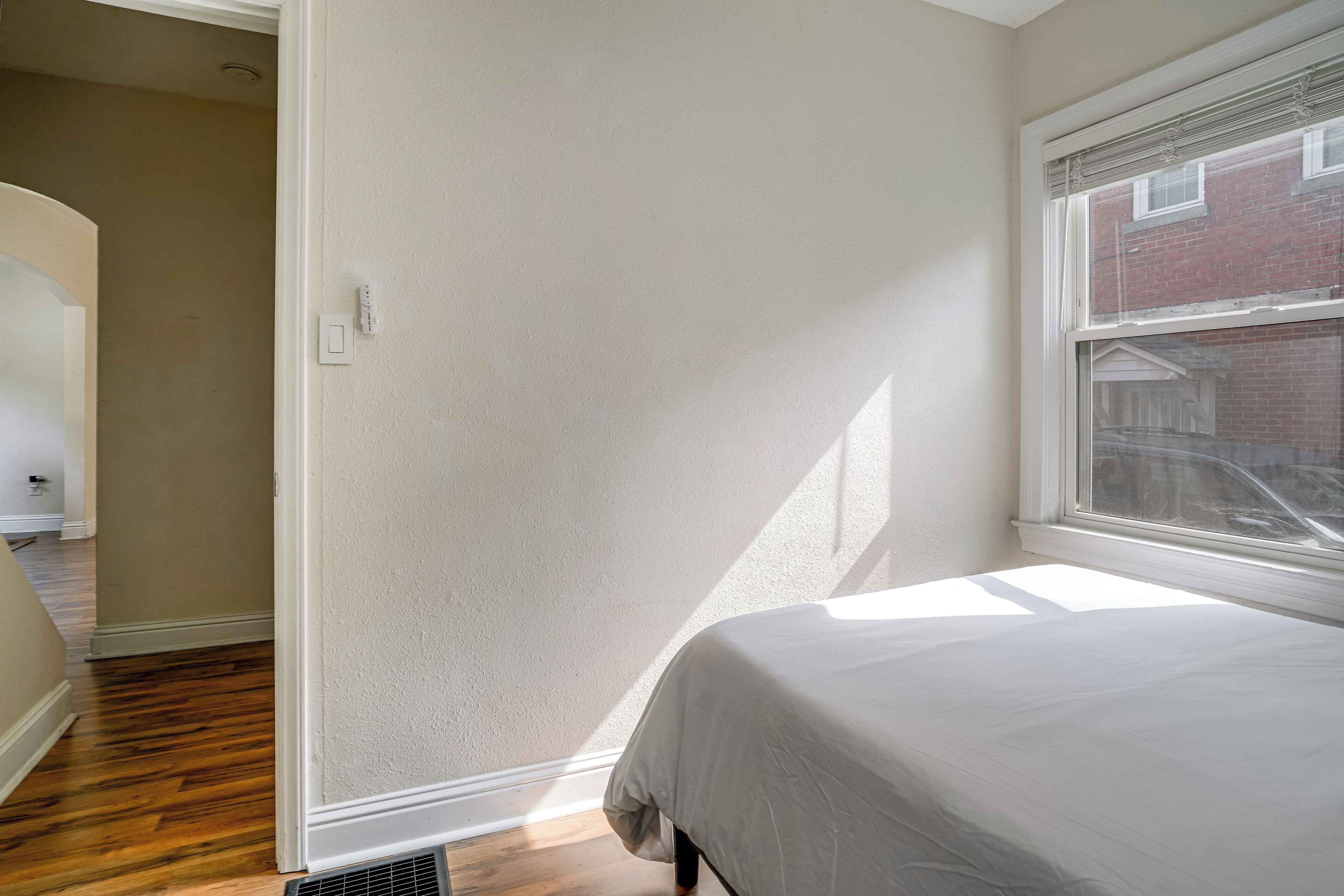 Une chambre à coucher avec un lit, une fenêtre et une porte.