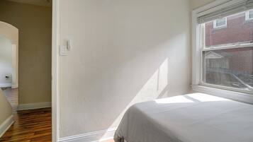 Une chambre à coucher avec un lit, une fenêtre et une porte.