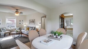 A modern living room with a round dining table, comfortable seating, and a ceiling fan. - Near Churchill Downs: Pet Friendly, Fenced Yard! (Louisville)