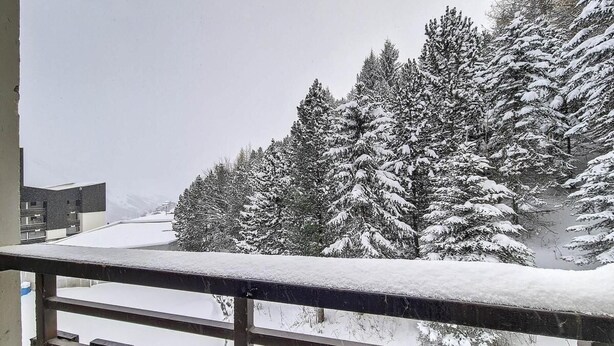 A snowy landscape with snow-covered trees and a balcony railing. - 2nd floor, balcony, tv, 24m², Les Menuires (Les Menuires)