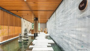 Un área de spa con techo de madera, pared de piedra y un cartel que indica la ubicación del spa.