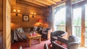A cozy wooden cabin interior with a sofa, chairs, and a table. - 115m from ski slopes, view panoramic, balcony, ski locker, 87m², Valmorel (Valmorel)