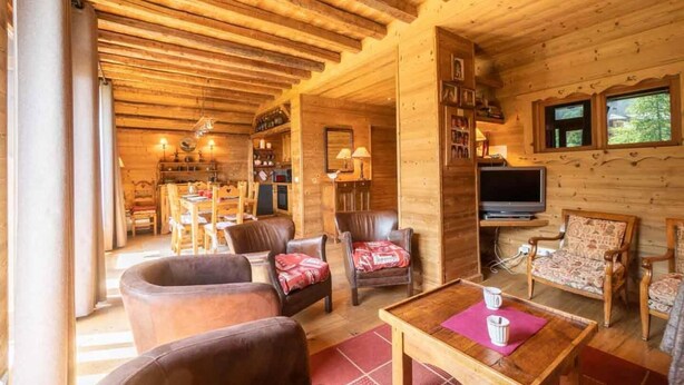 A cozy wooden cabin interior with a dining area, a living room with leather sofas, a television, and a fireplace. - 115m from ski slopes, view panoramic, balcony, ski locker, 87m², Valmorel (Valmorel)