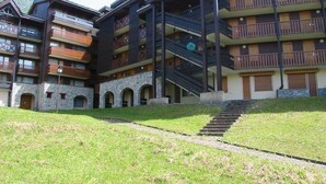 A multi-story hotel with balconies, a central staircase, and a stone facade. - 5m from ski slopes, 4th floor, terrace, ski locker, 24m², Valmorel (Valmorel)