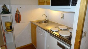 A compact kitchen with a sink, stove, and microwave. - 5m from ski slopes, 4th floor, terrace, ski locker, 24m², Valmorel (Valmorel)
