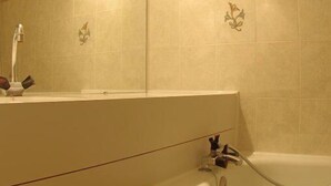 Un baño con bañera, lavamanos y espejo.