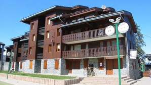 A multi-story building with a wooden facade, balconies, and a ski-pass kiosk. - 1st floor, view mountain, tv, 24m², Valmorel (Valmorel)