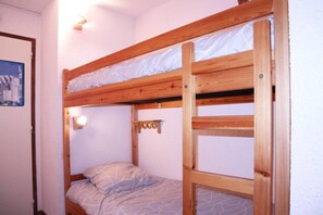 A bunk bed with a headboard and a small shelf.