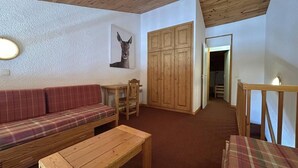 A cozy living room with a wooden ceiling, a plaid sofa, a wooden table, and a wooden cabinet. - 150m from shops, 5th floor, view ski slopes, balcony, ski locker, 60m², Méribel-Mottaret (Méribel - Les Allues)