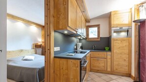 A compact kitchen with wooden cabinets, a built-in oven, and a small countertop.