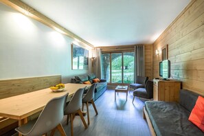 A modern interior with a dining area, sofa, and television. - 80m from ski lifts, view ski slopes, terrace, ski locker, 43m², Méribel-Mottaret (Méribel - Les Allues)
