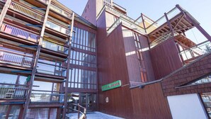 A multi-story building with a wooden facade, balconies, and a sign reading "LES LAUZIÈRES". - 100m from resort center, 8th floor, balcony, tv, 27m², Les Arcs (Les Arcs)