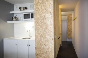 Eine moderne Küche mit weißen Schränken, einer Edelstahl-Spüle und einer Mikrowelle.